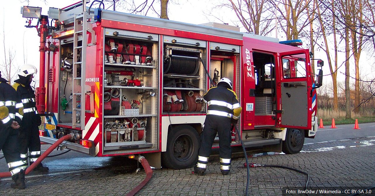 Brandweerlieden bij een tankautospuit